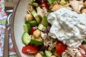 High-protein salad bowl with chicken, chickpeas, vegetables, and creamy topping